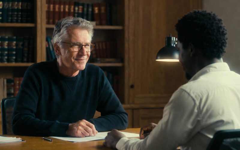 Professor and student discussing a scholarship recommendation letter in an office